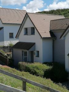 een wit huis met een bruin dak bij Equihen Plage Maison 83 in Équihen-Plage