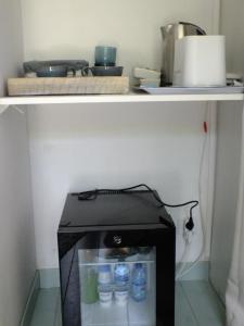 a microwave with bottles of water inside of it at casa turchina chambre avec piscine privée in Porto-Vecchio