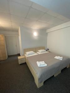 a bedroom with a bed with two towels on it at Pensiunea Ambasador in Băile Herculane +11 photos