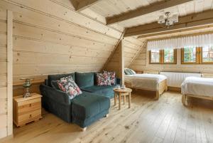 a living room with a blue couch and a bedroom at Willa Hiacynta in Zakopane