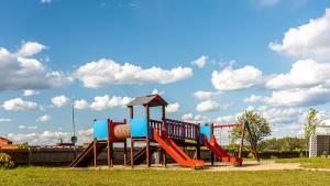 a playground with a slide in a park at Camping Marina Nowe Guty in Nowe Guty