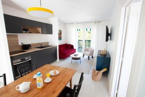 cocina y sala de estar con mesa de madera en una habitación en Villa Aitama en Cap-Ferret