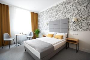 a bedroom with a large bed with yellow pillows at Apartamenty Klasztorna 25 in Poznań