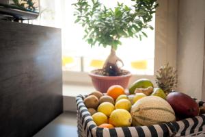 a basket of fruit on a table with a potted plant at Hotel Perla in Castiglione della Pescaia
