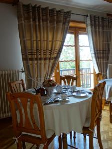 a dining room table with a white table cloth at La Maison Fleurie in Dieffenbach-au-Val