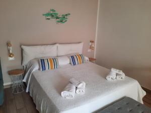 una camera da letto con un letto bianco e asciugamani di Casa di Maddalena a Castellammare del Golfo