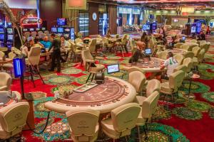 a casino with tables and chairs and people playing poker at Platinum Hotel & Casino in Sunny Beach