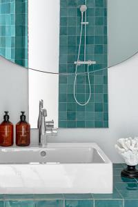 a bathroom with a tub and a green tile wall at Maison des Ambassadeurs in La Rochelle