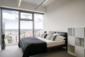 1 dormitorio con cama y ventana grande en RentPlanet - Apartamenty Sky Tower, en Wroclaw