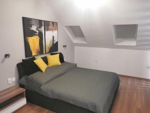 a bedroom with a bed with two yellow pillows at Kék Lagúna Panzió in Dombrád