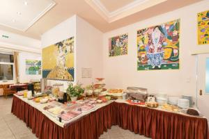 ein Buffet-Tisch mit Essen auf dem Zimmer in der Unterkunft Garten- und Kunsthotel Gabriel City in Wien