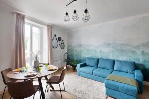 een woonkamer met een blauwe bank en een tafel bij Le Cotissois in Lanvallay