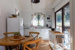 a kitchen with a wooden table and a refrigerator at Bandalong Cottages in Mudgee