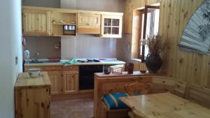 - une cuisine avec des placards en bois, une table et une cuisinière dans l'établissement Camigliatello Mom&Son, à Camigliatello Silano