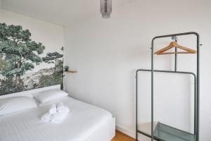 a bedroom with a bed with two towels on it at L'Opalin by Cocoonr - en plein cœur de Dinard in Dinard