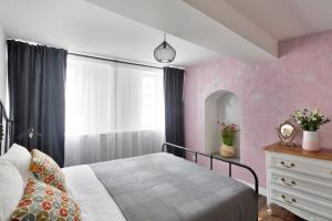 a bedroom with a bed and a dresser and a window at La Belle à Colombage in Dinan +6 photos