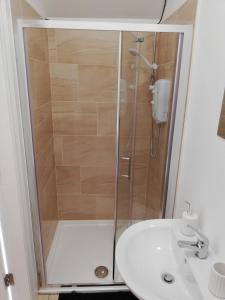 La salle de bains est pourvue d'une douche et d'un lavabo. dans l'établissement The Forge Apartments, à Causeway