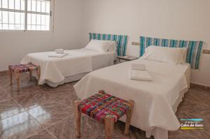 two beds in a room with two tables and a chair at LA CALILLA II in San José