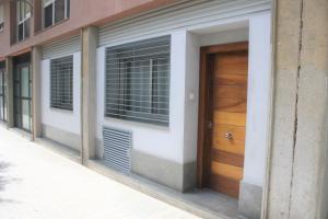 un edificio con una puerta de madera en una calle en Alguera Hola Apartments, en Barcelona