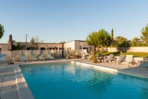 einen Pool mit Liegestühlen und einem Pool in der Unterkunft Le Pigeonnier du Perron Hôtel in Availles en Chatellerault