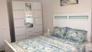 a bedroom with a bed with a blue and white comforter at Eric Apartament’s Suite in Şelimbăr