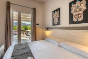 una camera da letto con un letto e un balcone di Tramonto Ibleo Resort ad Avola Altre 183 foto