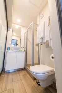 a white bathroom with a toilet and a sink at The Regency Menlyn in Pretoria