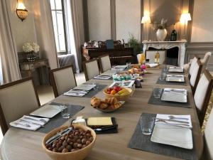 une longue table avec des bols de fruits sur elle dans l'établissement Le Château d'Hermonville B&B / Chambres d'hôtes, à Hermonville