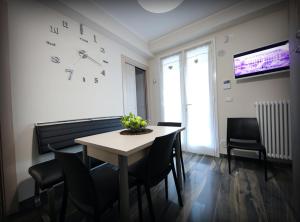 a dining room with a table and chairs and a clock at Villa Solemar Holidays in Avola