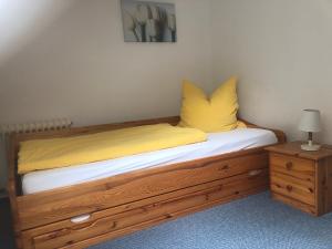 Un dormitorio con una cama con almohadas amarillas. en Ferienwohnung Waldruhe, en Hessisch Oldendorf