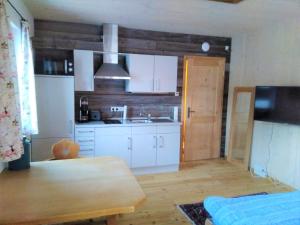 a kitchen with white cabinets and a wooden table at Country Appartement Lungau in Sankt Margarethen im Lungau