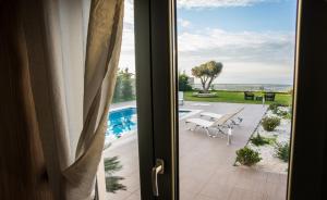 a door to a patio with a view of the ocean at Villa Horizon in Skouloúfia