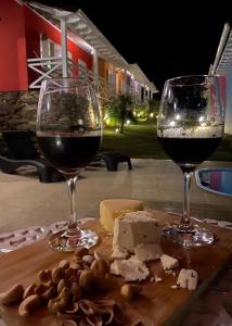 拉夫拉斯魯巴的住宿－Biz & Biu Pousada Lavras Novas，桌子上放两杯葡萄酒和奶酪