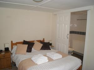 ein Schlafzimmer mit einem großen Bett mit zwei Kissen in der Unterkunft King's Arms in Lostwithiel