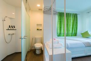 a bathroom with a bed and a shower and a toilet at Chada@Nakhon in Nakhon Si Thammarat