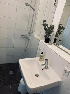 een witte badkamer met een wastafel en een douche bij Wanderlust Trier in Trier