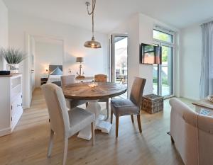 a kitchen and dining room with a table and chairs at Ferienwohnung TreibGood in Glowe