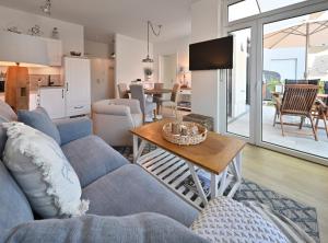 a living room with a blue couch and a table at Ferienwohnung TreibGood in Glowe