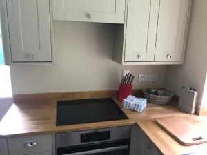 Una cocina con gabinetes blancos y encimera. en North Lodge, en Invergarry 4 fotos más