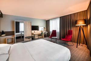 a hotel room with a bed, chair, desk and a television at Park Inn by Radisson Krakow in Krakow