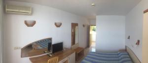 a living room with a couch and a tv on a wall at Hotel Oasis - Beach Access in Balchik