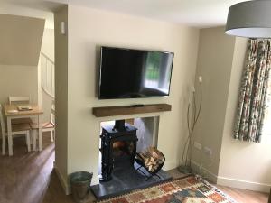 a living room with a fireplace with a tv above it at North Lodge in Invergarry