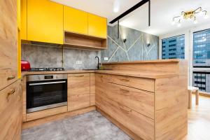 una cucina con armadi gialli e piano cottura di Warsaw Central Apartments by Renters a Varsavia