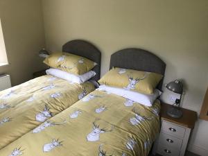 Un dormitorio con una cama con una colcha con insectos. en North Lodge, en Invergarry