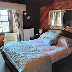 a bedroom with a large bed and a mirror at The Spindrift Guest House in Anstruther