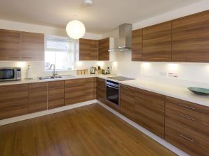 a kitchen with wooden cabinets and a sink at tulips in Fort William