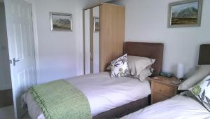 a small bedroom with a bed and a night stand at tulips in Fort William