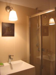 a bathroom with a shower and a sink and a mirror at Studio 4U Zakopane APARTZAKOP in Zakopane