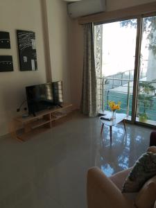 a living room with a television and a couch at Aqua Royal Holiday Apartments Girne in Kyrenia