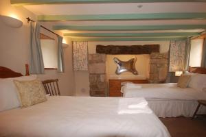 een slaapkamer met 2 bedden en een stenen muur bij Granary at Trewerry Cottages - Away from it all, close to everywhere in Newquay